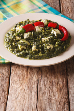 Indian Palak Paneer Spinach with cheese and spices close-up. Vertical
