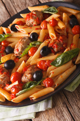 Italian Food: Pasta with meatballs, olives and tomato sauce closeup. Vertical
