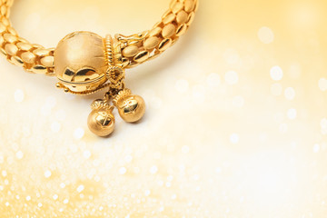 gold bracelet on shiny bokeh background