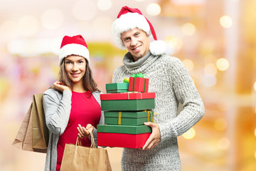 Young couple with Christmas purchases on blurred market background. Christmas shopping concept.