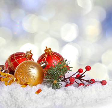 Christmas decoration on snow against bright blurred background.
