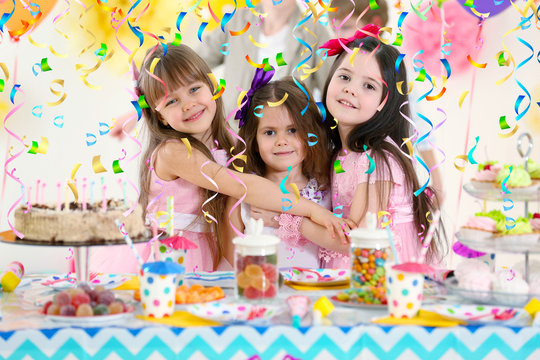 Happy little girls hugging at birthday party