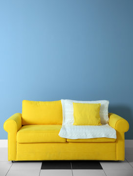 Yellow sofa on blue wall background