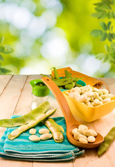  image of beans in pods on a wooden table closeup