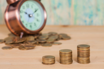 coins stack and alarm clock on  background , business concept