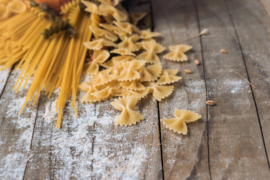 Various mix of pasta on wooden rustic background