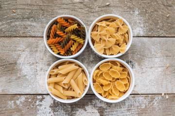 Various types of pasta on wooden rustic background