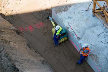 Bauarbeiter verdichten Baugrund