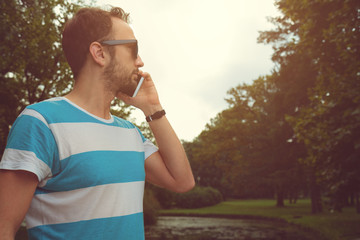 Fototapeta premium Guy talking on his smartphone outdoors.