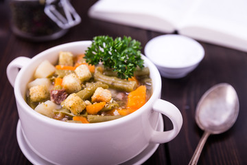 Bohneneintopf mit frischer Petersilie auf Holz