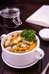 Bohneneintopf mit frischer Petersilie auf Holz