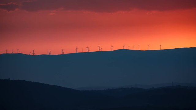 Clean Energy with wind turbines at sunset, time lapse