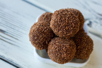 Candies covered in crumbs. Little brown desserts. Delicious chocolate rum balls. Recipe of dessert with alcohol.