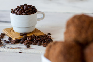 Cup of coffee grains. Dark beans on wooden surface. Main source of caffeine. Get boost of energy.