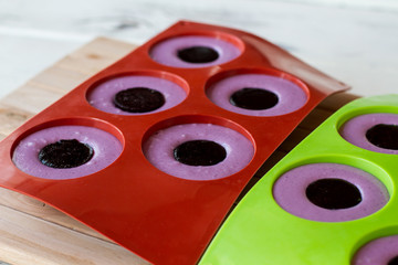 Desserts in silicone molds. Sweets of purple color. Delicious blueberry mousse. No bake cake recipe.