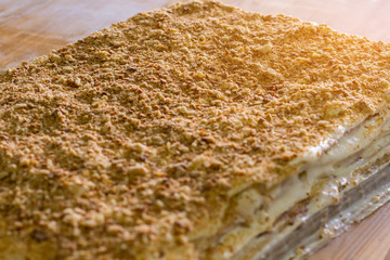 Big layered cake. Cream and crumbled biscuits. Freshly cooked millefeuille. Simple and tasty dessert.