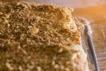 Dessert with cookie crumbs. Cake under sunlight. Puff dough and cream. Freshly made sweet dish.