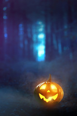 Leuchtender Halloween-Kürbis im nebeligen Wald