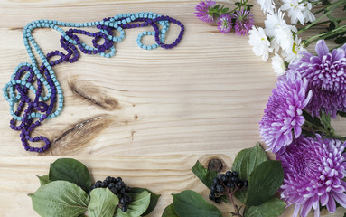 beautiful flowers and jewelry on a wooden background