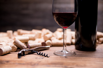 wine concept still life with bottle and glass of wine, corks and corkscrew