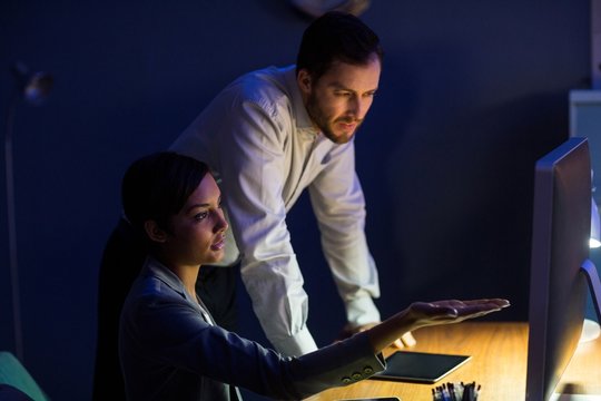 Businesswoman discussing with colleague over digital tablet