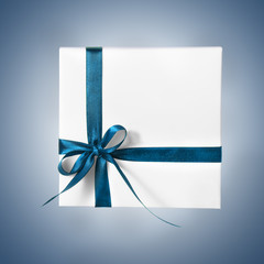 Isolated Holiday Present White Box with Blue Ribbon on a gradient background