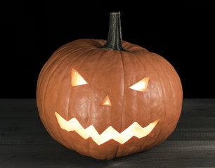 Halloween carved pumpkin, jack-o-lantern on wooden table