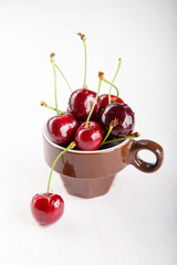 Juicy fresh cherries in brown cup