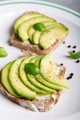 Sandwich with avocado slices and basil