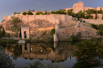 Toledo al anochecer con la muralla, el río Tajo y el monasterio de San Juan de los Reyes