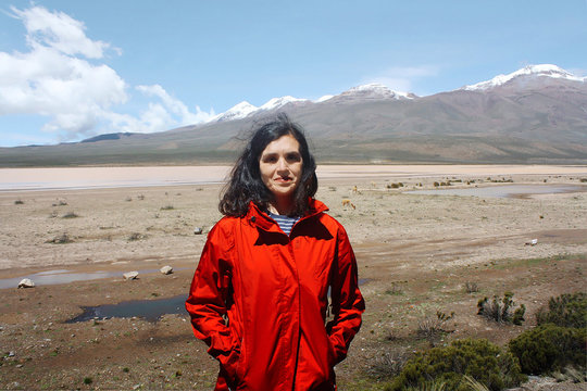 woman near Llamas and alpacas graze in mountains near Arequipa