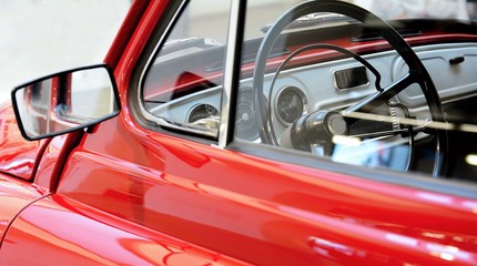 Side view through a window to interior of classic vintage red car.