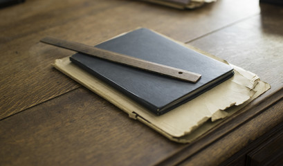 Old ruler, notebook, file on a top of wooden table
