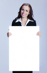 Businesswoman showing signboard, over grey