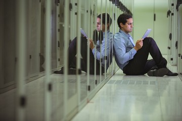 Technician siting on chair and using digital tablet