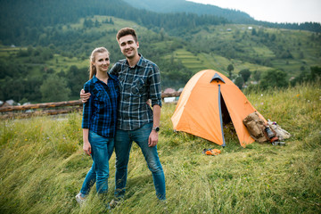 Fototapeta na wymiar Guy and girl lovers tourists relax and admire beautiful mountain scenery