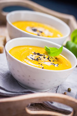 Homemade vegetable soup with pumpkin with cream and black sesame, closeup