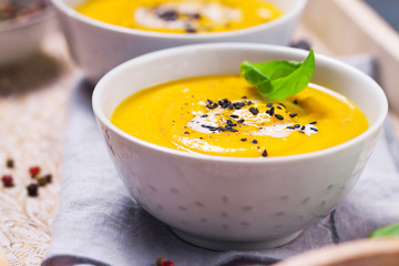 Homemade vegetable soup with pumpkin with cream and black sesame, closeup