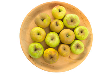 Wooden bowl full of imperfect looking organic apples with unconventionally raised method, no genetically modified organism techniques