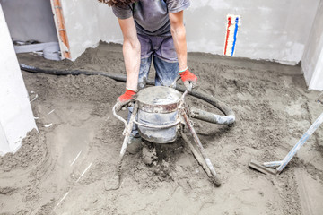 Employee performs sand and cement screed floor.