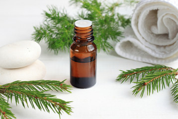 Green eco cosmetics spa treatment. Essential oil, aromatic pine twigs, white towels. Relaxing beauty care.