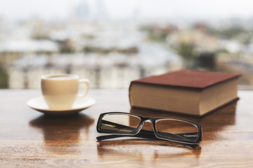 Glasses, coffee cup and book