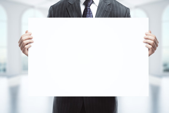Businessman holding blank whiteboard