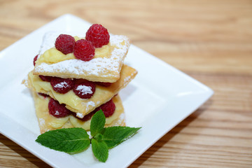 Puff pastry with mint leaves and raspberries, background with copy space 