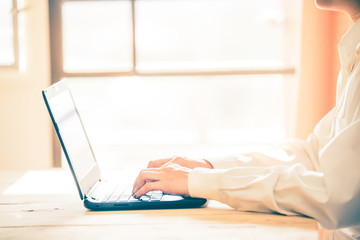 Fototapeta premium Business women hands working with laptop on wooden desk, lighing effect