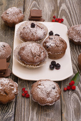 cupcake with berries on a white plate, wooden background