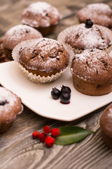 cupcake with berries on a white plate, wooden background