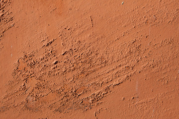 Old terracotta painted stucco wall with chipped paint. Backgroun