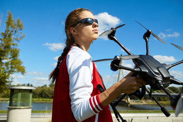 Fototapeta premium A woman is standing and holding drone