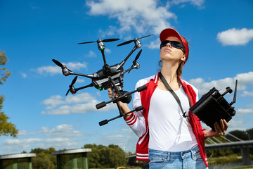 A woman is standing and holding drone